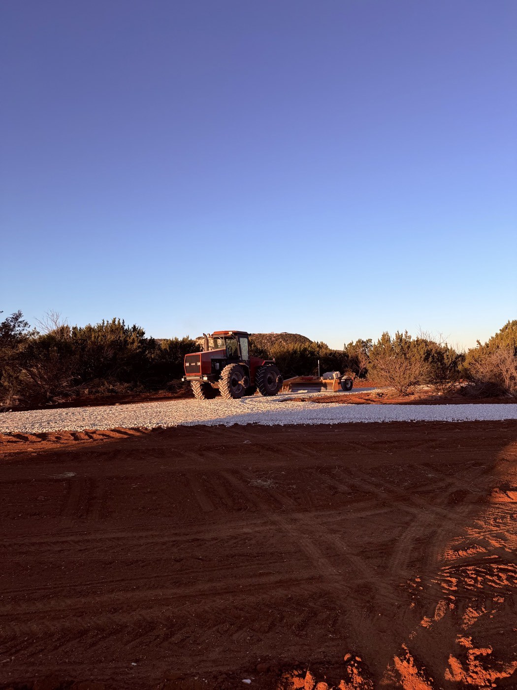 Tractor grading a caliche strip