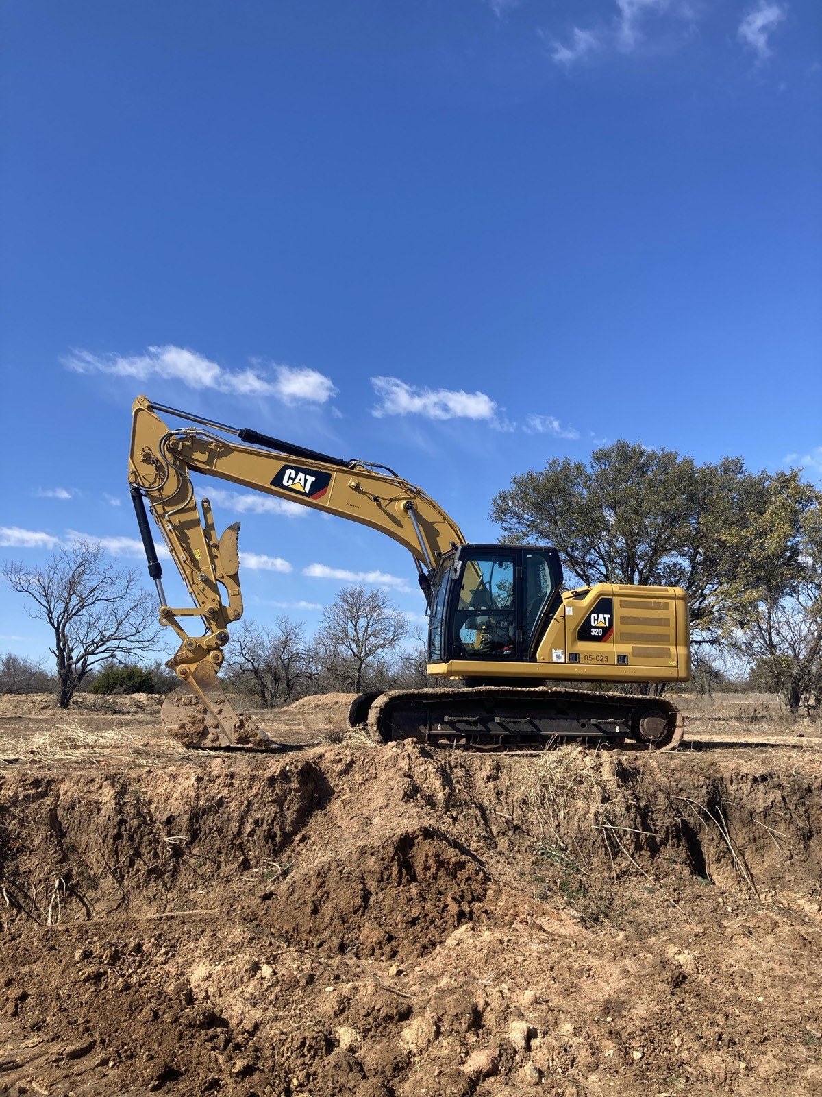 CAT excavator working a dirt mound